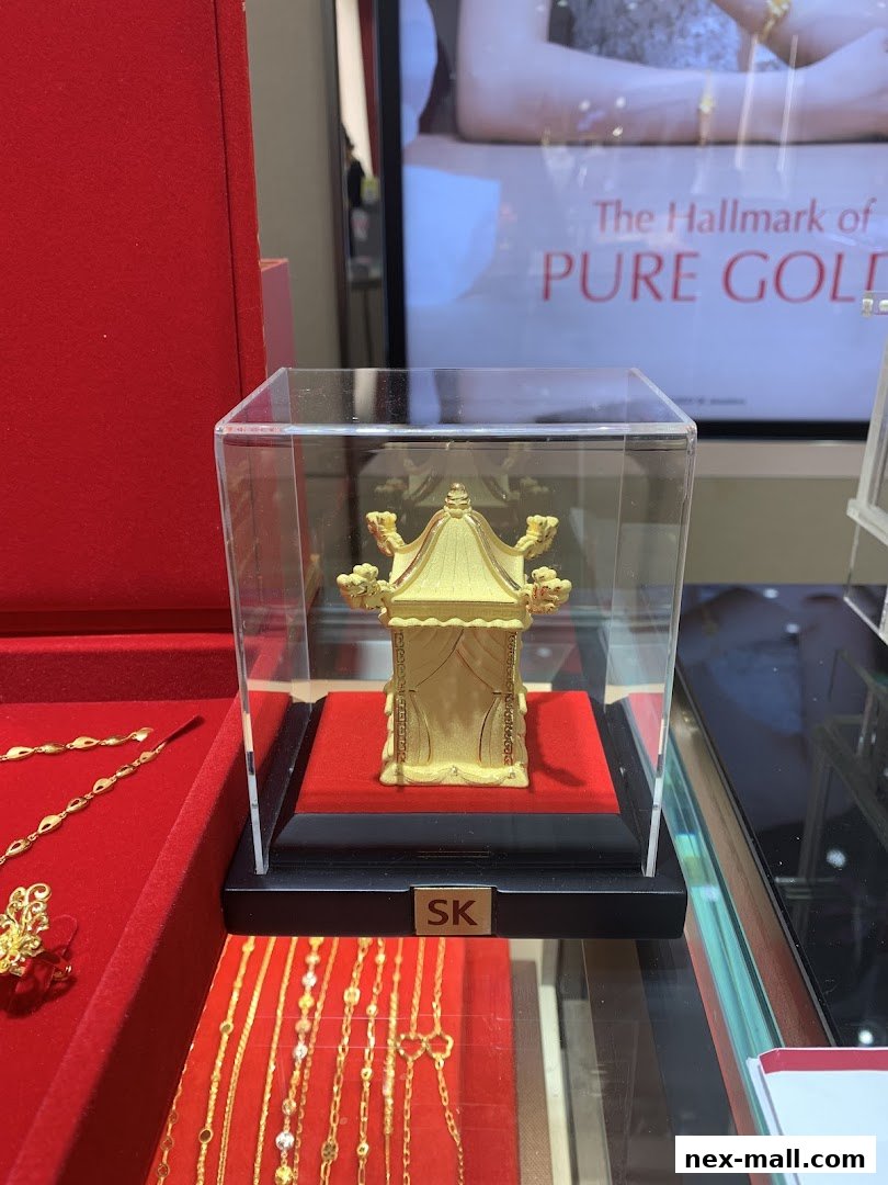 A display of intricate gold jewelry, including a miniature pagoda, in a retail store.