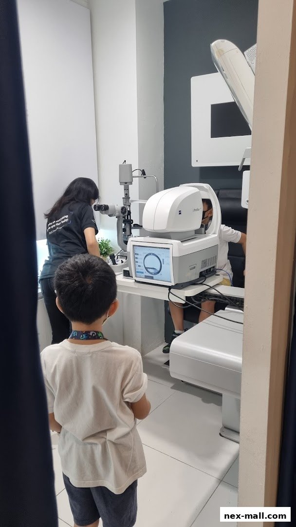 An optometrist examines a child's eyes using advanced optical equipment.