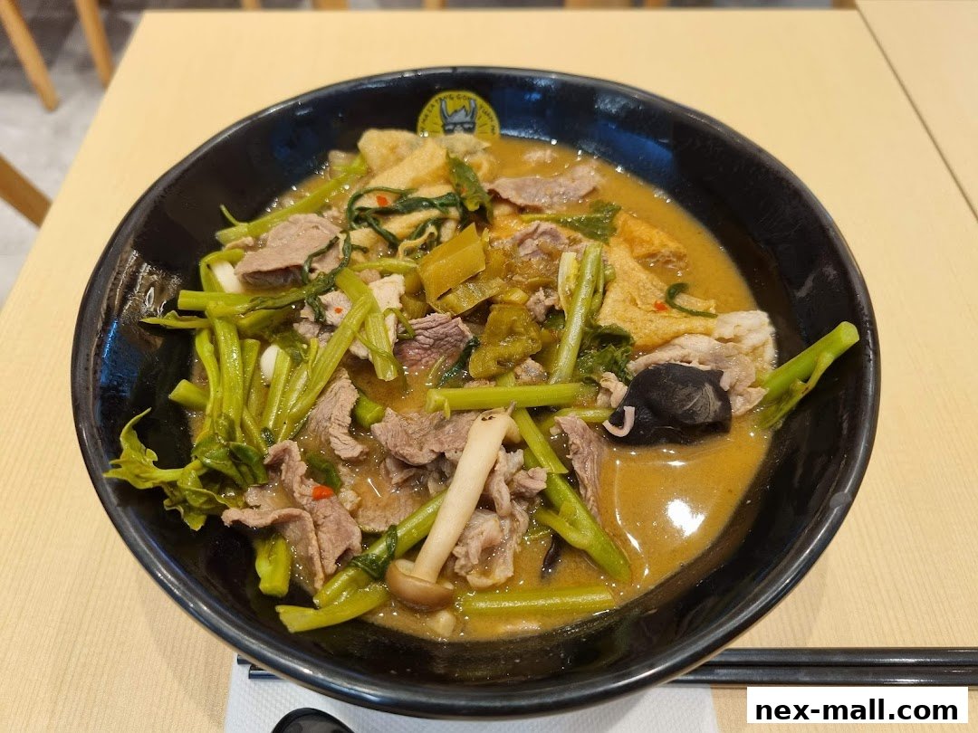 A close-up shot of a steaming bowl of Mala Tang with beef, vegetables, and mushrooms.