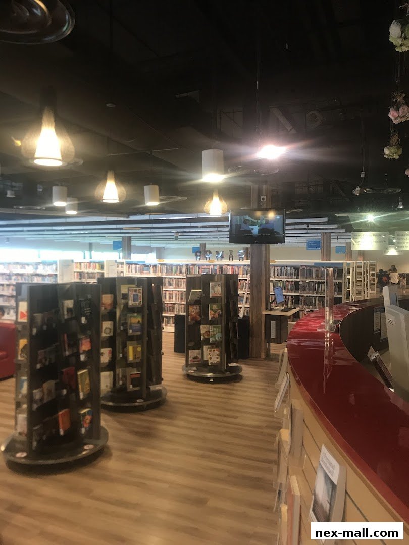 Interior view of a modern library with bookshelves, display stands, and a service counter.