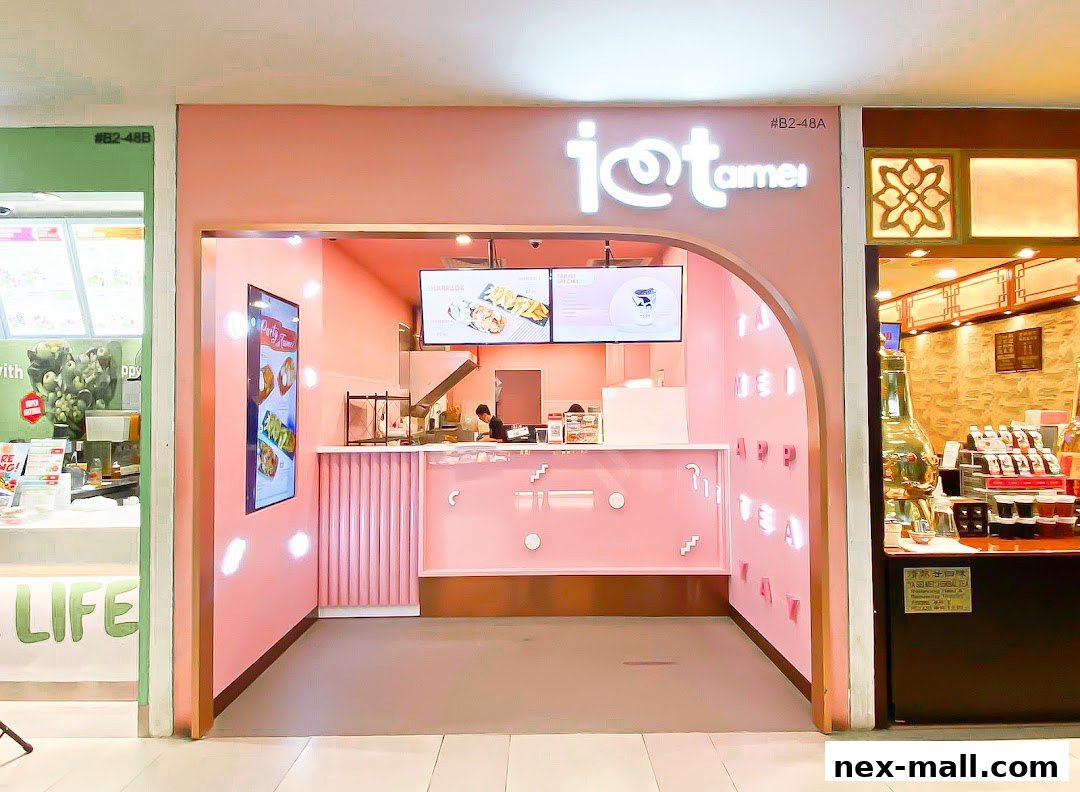 The pink storefront of 'I Love Taimei' features a counter, digital menus, and neon signage.