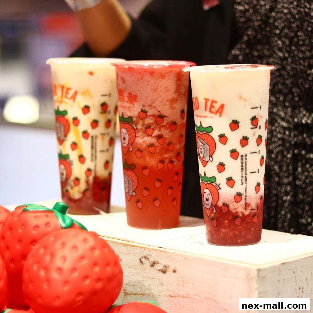 Three refreshing LiHO TEA drinks with strawberry designs and decorative strawberries in the foreground.
