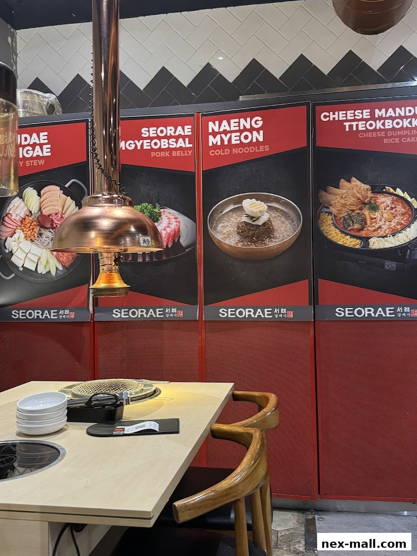 A table setting at a Korean restaurant with images of various dishes on the wall.