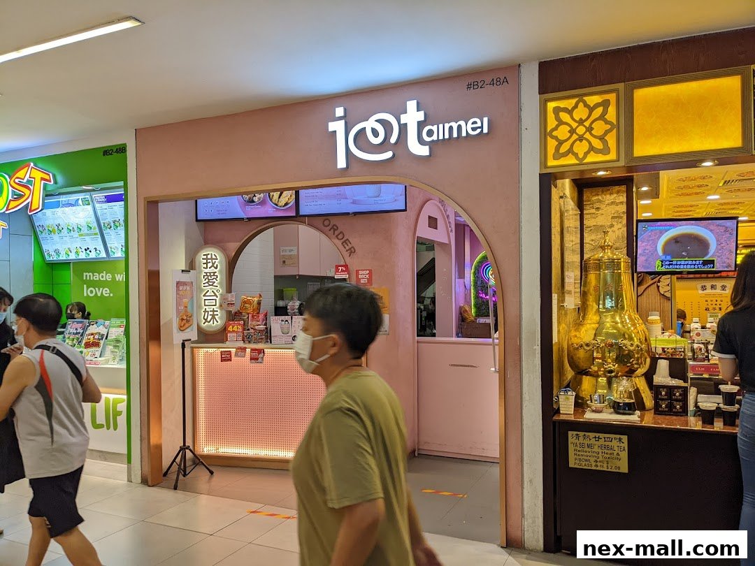 The entrance of the "I Love Taimei" shop, a pink-themed establishment with a prominent logo and menu displays.