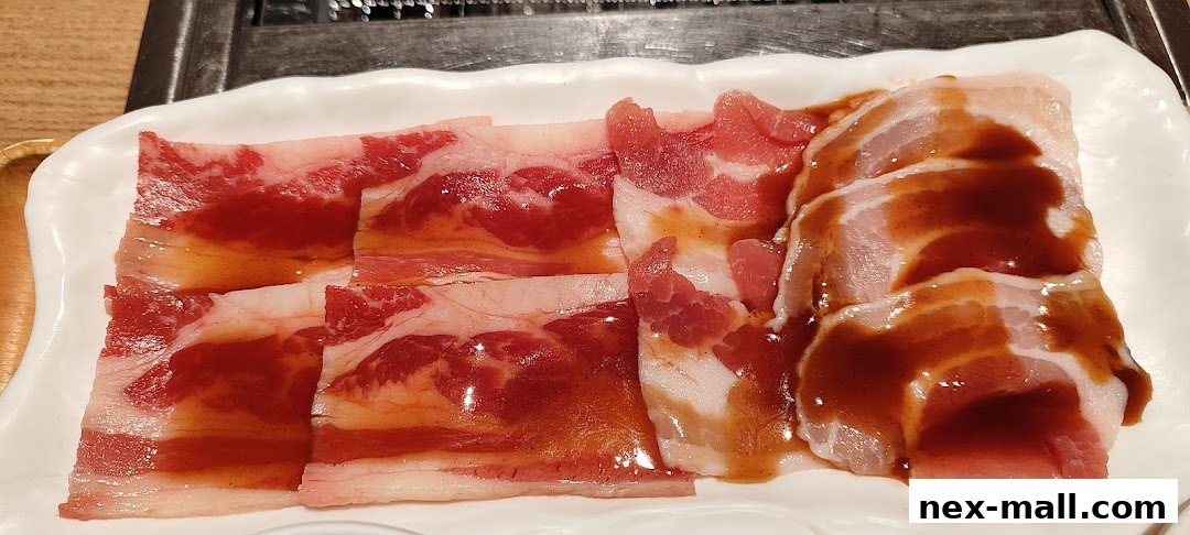 A white plate filled with thinly sliced raw pork belly marinated in a savory sauce.