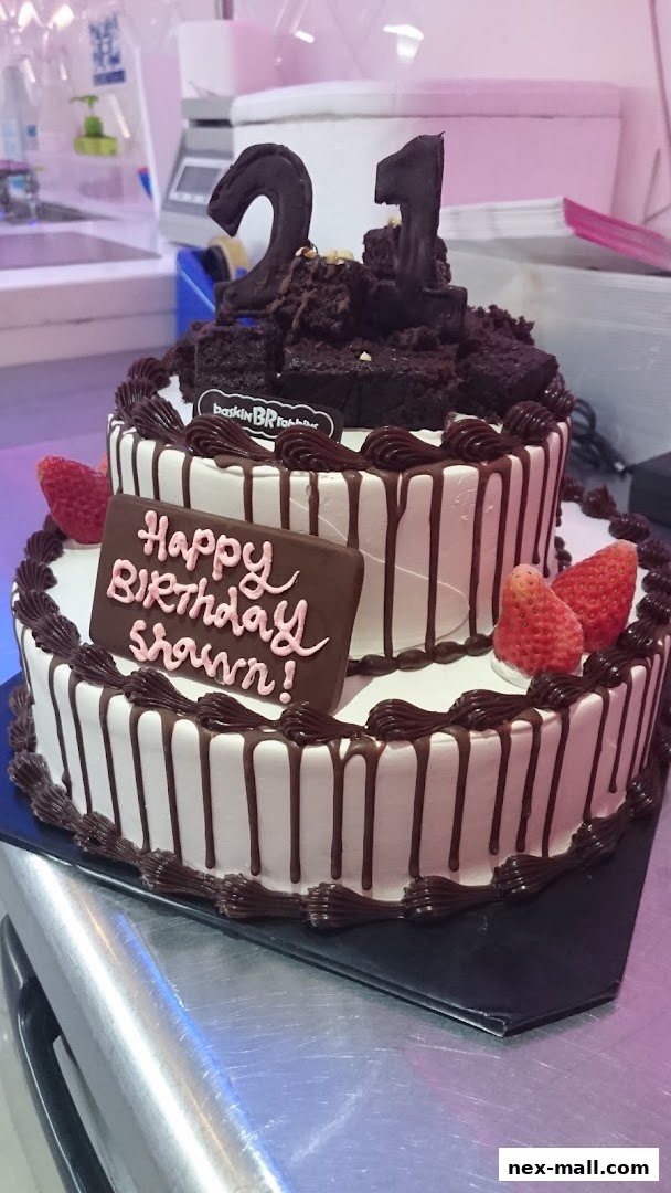 A two-tiered birthday cake with chocolate decorations and strawberries, celebrating a 21st birthday.