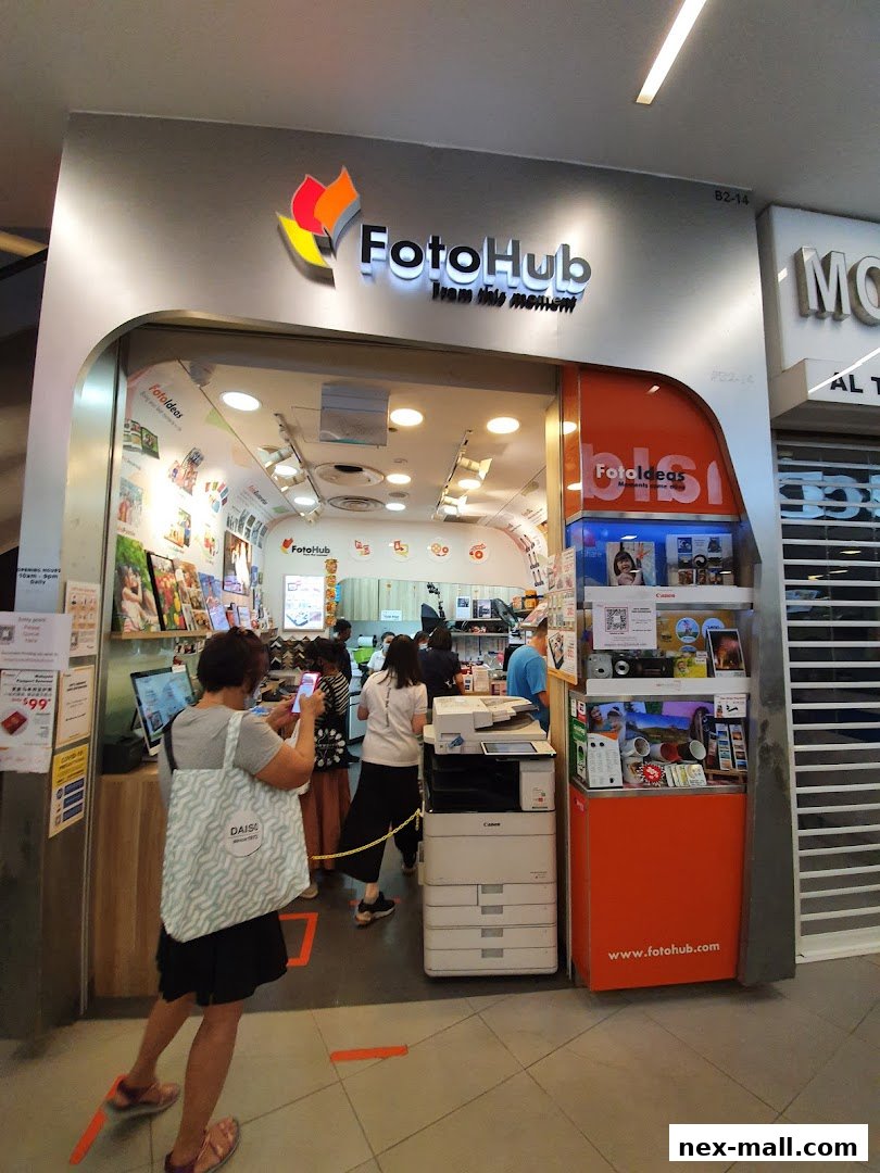 The entrance of FotoHub, a photography store, with customers inside and displays of photos and products.