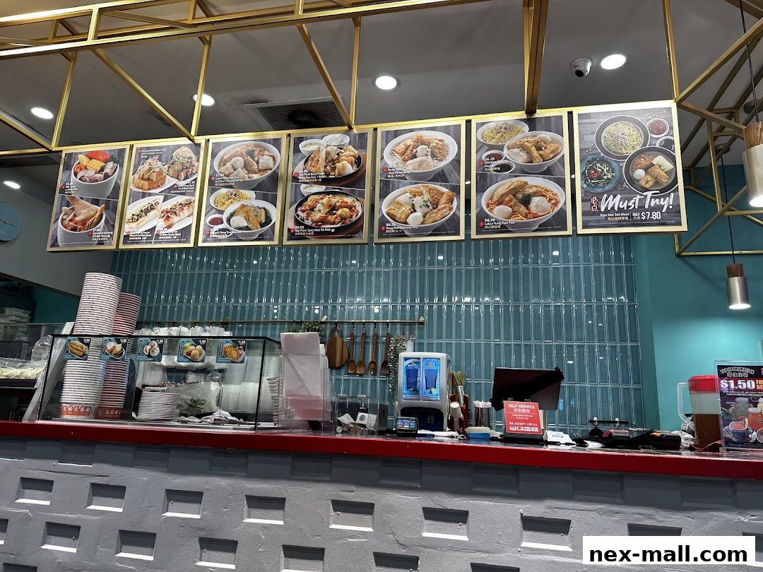 A counter display with food pictures and menu items at Koo Kee restaurant.