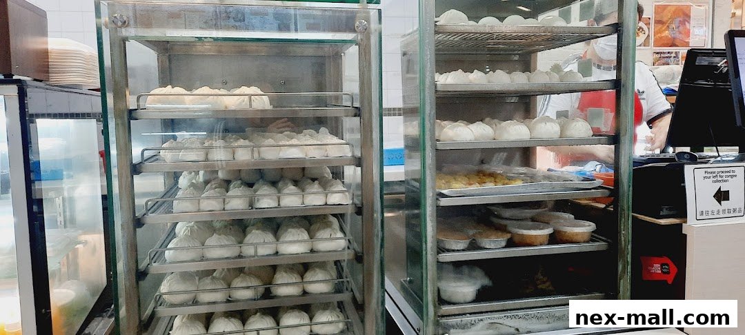 Steaming hot buns and other food items displayed in glass cabinets at Ho Kee Pau.