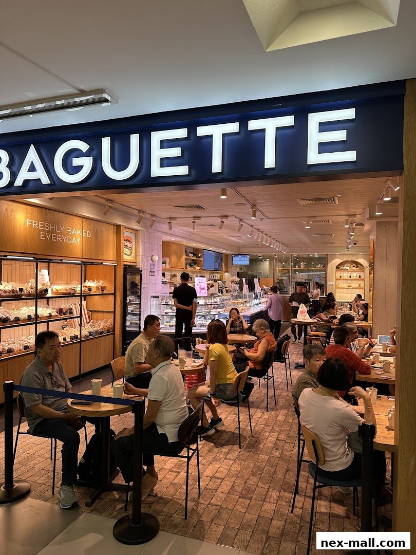 Interior view of Paris Baguette NEX with customers seated at tables and baked goods displayed.