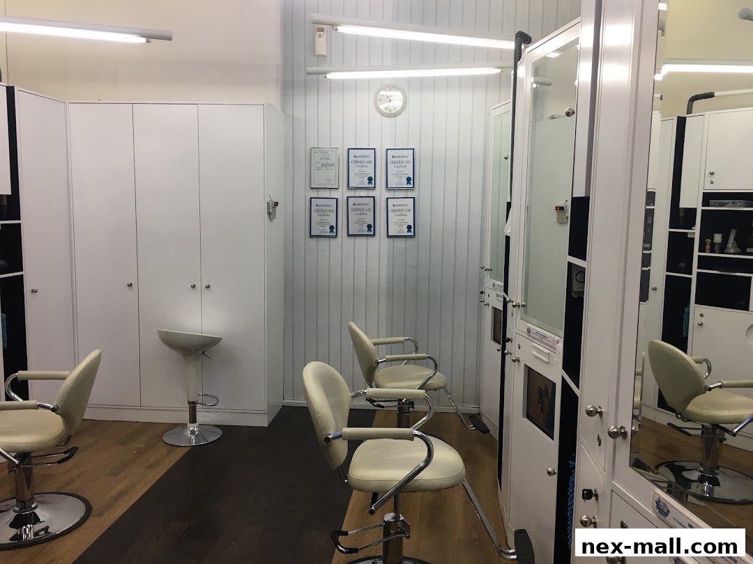 Interior of a clean, modern hair salon with styling chairs and mirrors.