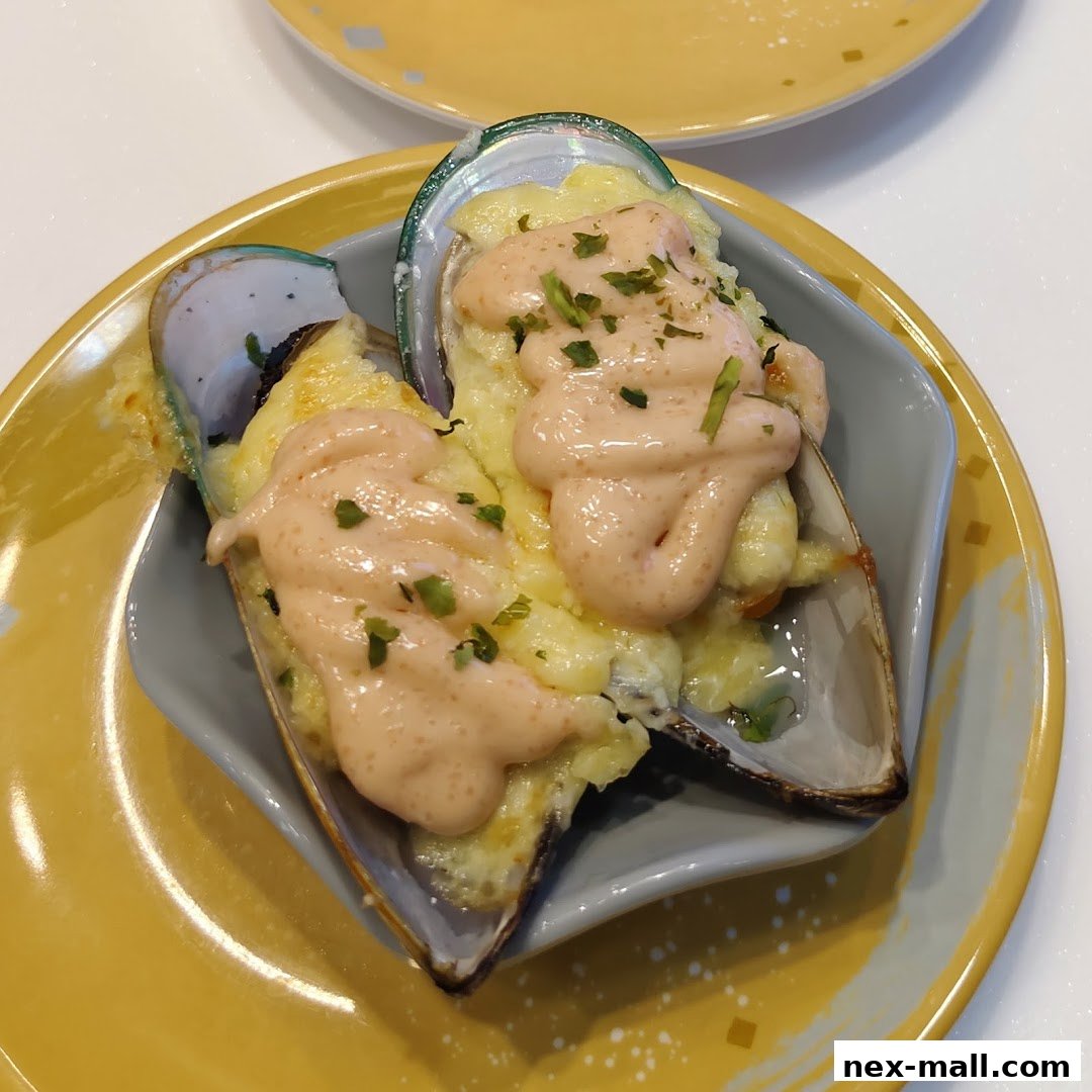 Two baked mussels topped with cheese and sauce served on a yellow plate.