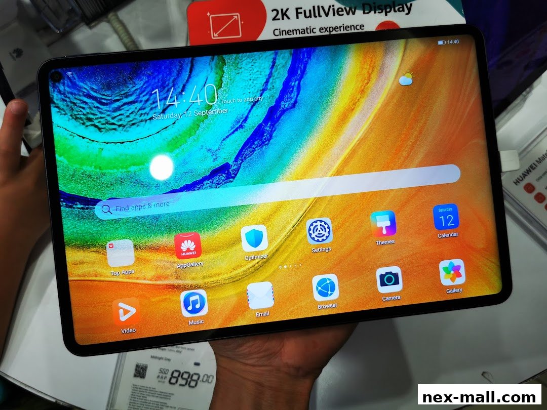 A person holds a Huawei tablet displaying its home screen with various apps and a price tag below.