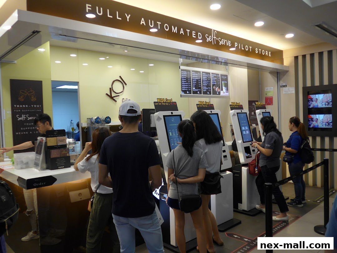 Customers ordering at self-serve kiosks in a KOI Thé bubble tea store.