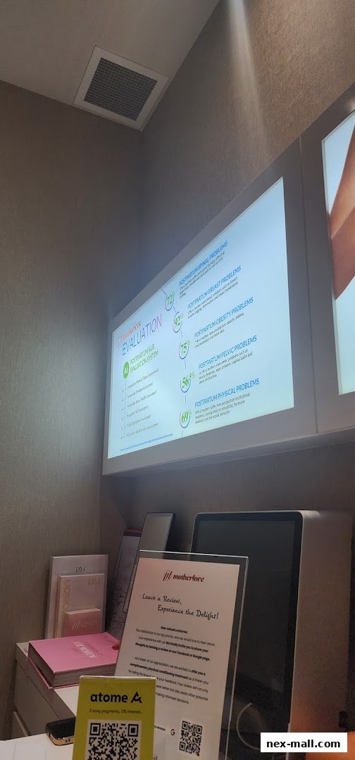 A screen displays postpartum evaluation data, with a review request sign and products on a counter.