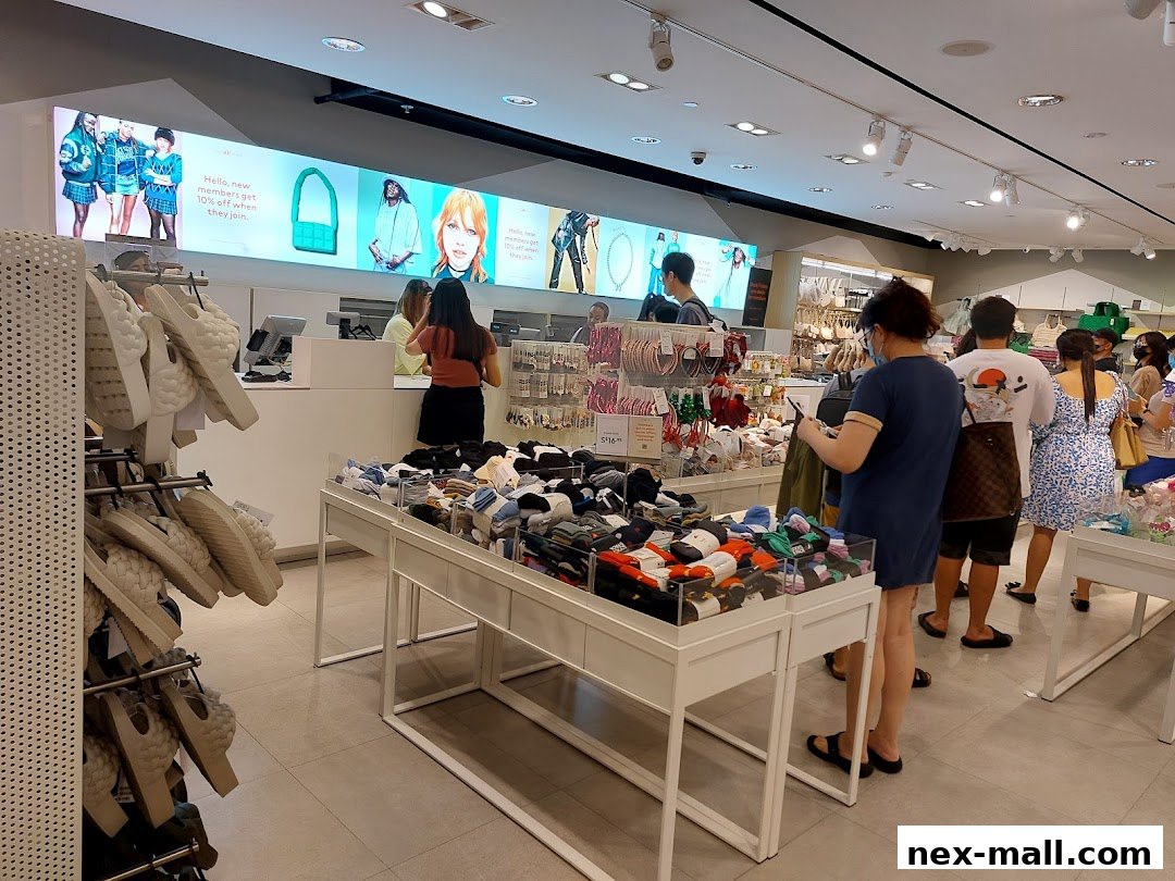 Interior view of an H&M store with customers browsing merchandise and a display of socks.