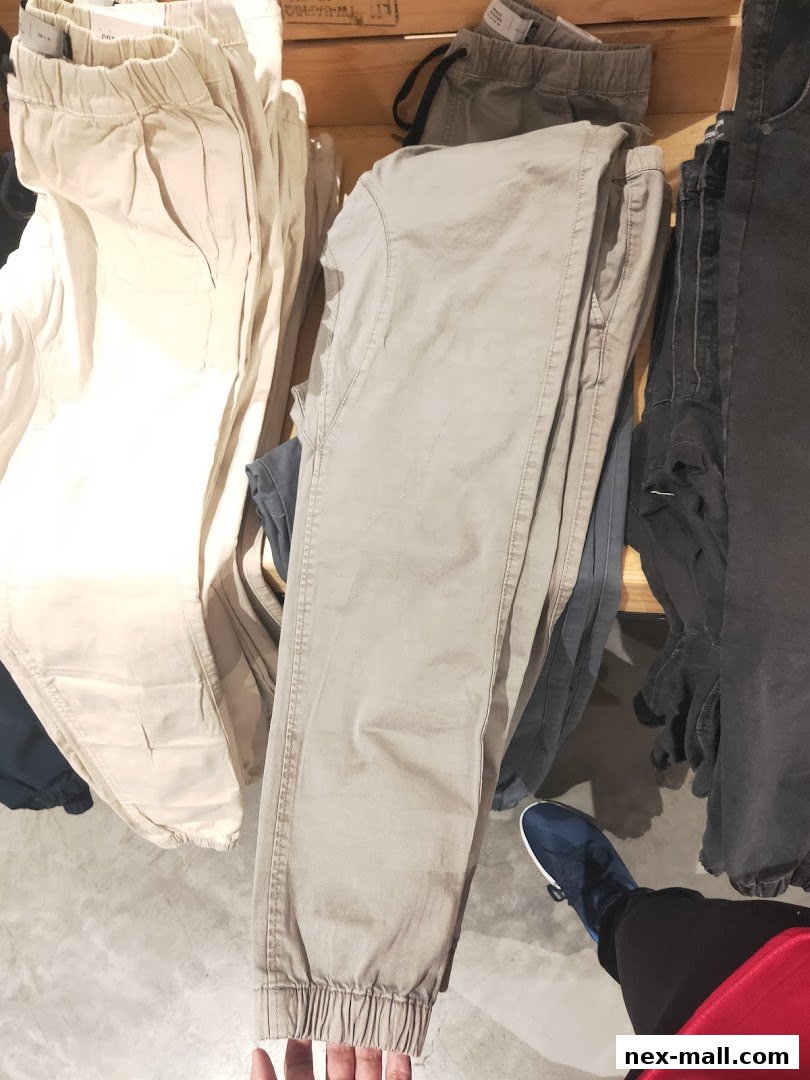 A close-up view of folded beige and grey pants displayed in a retail store.