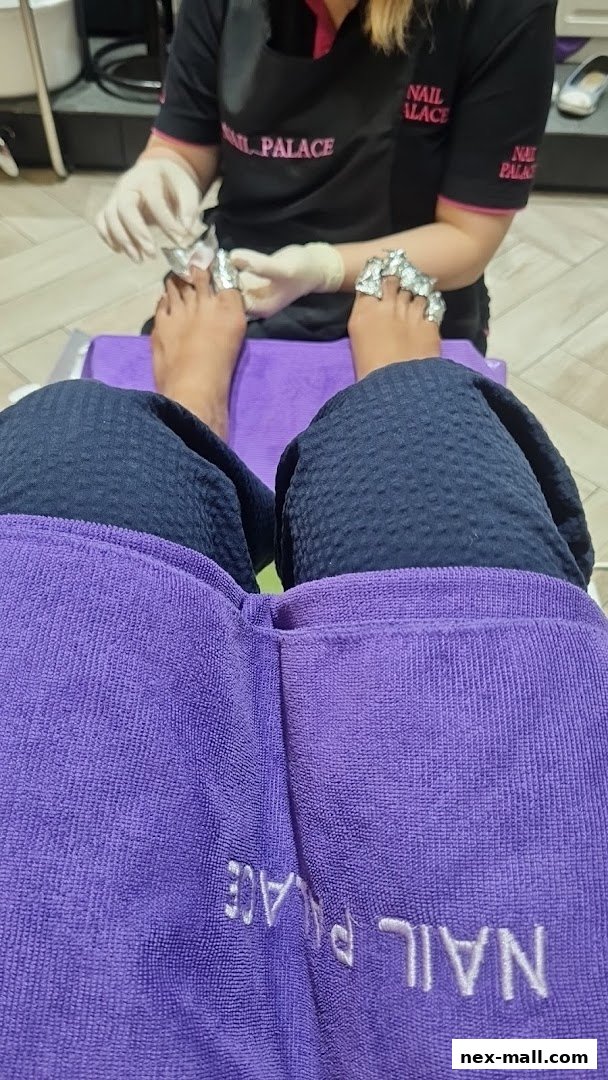 A person receiving a pedicure at Nail Palace, with foil on their toes.