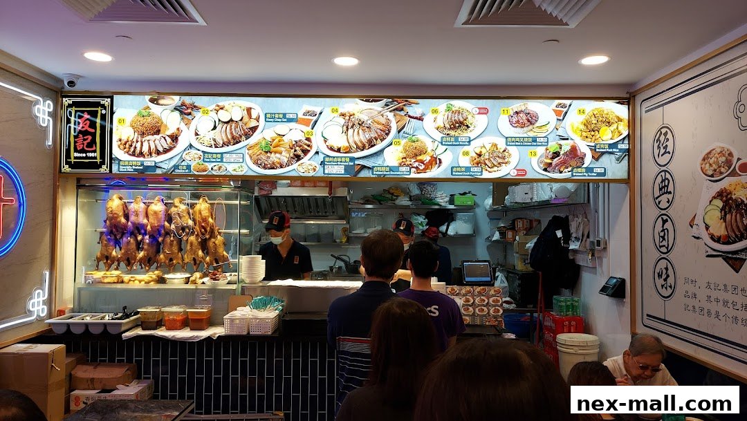A busy food stall with roasted ducks hanging and a menu board displaying various dishes.