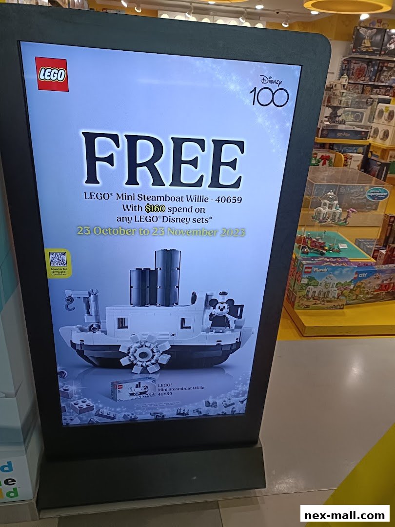 A digital display advertises a free LEGO Mini Steamboat Willie set with a $160 Disney purchase.