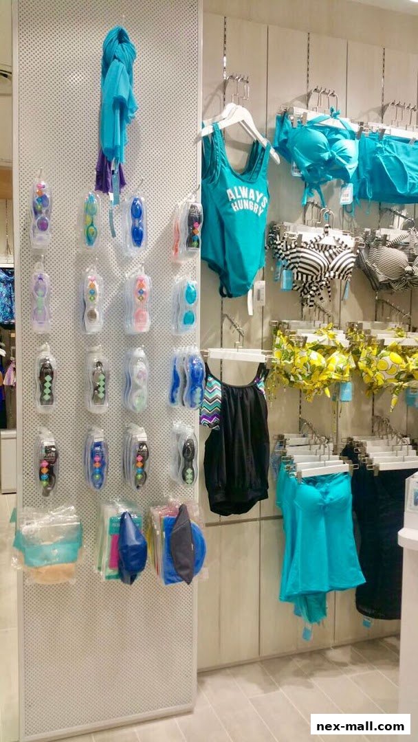 A retail display featuring swimwear, goggles, and scarves in various colors.