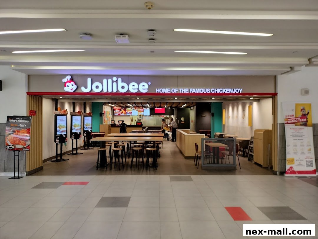 The entrance to a Jollibee restaurant with seating and ordering kiosks visible.