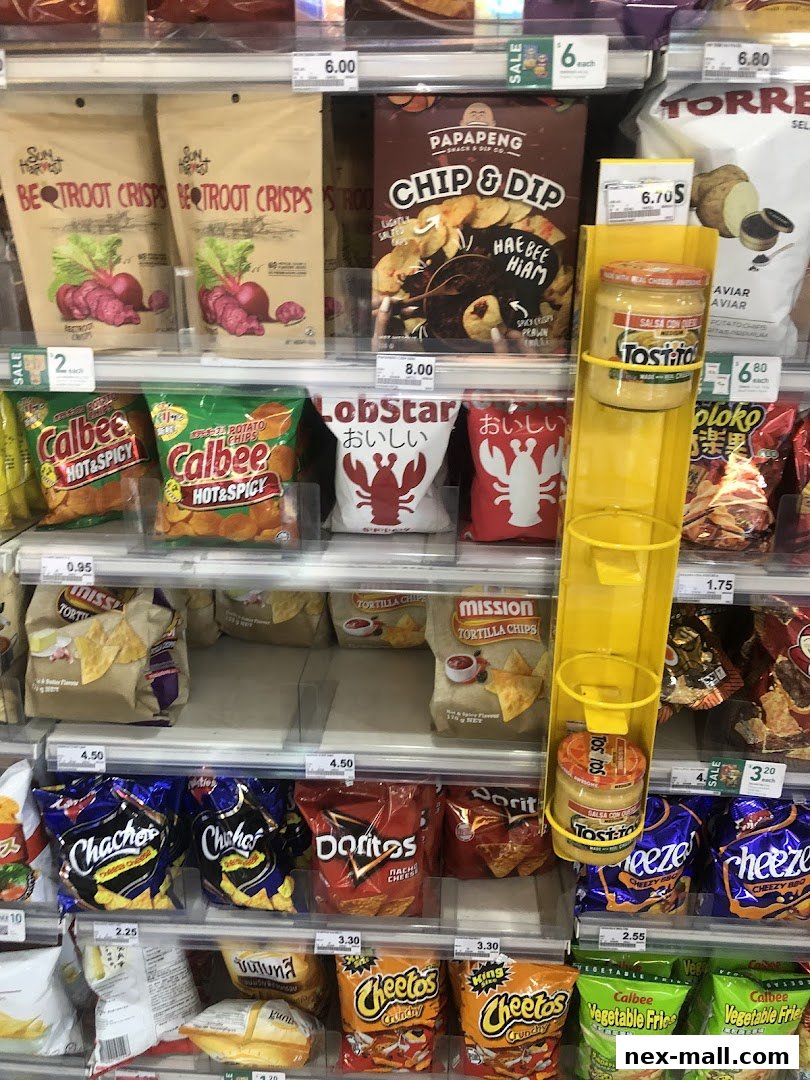 A display of various snack bags and dips on shelves in a convenience store.