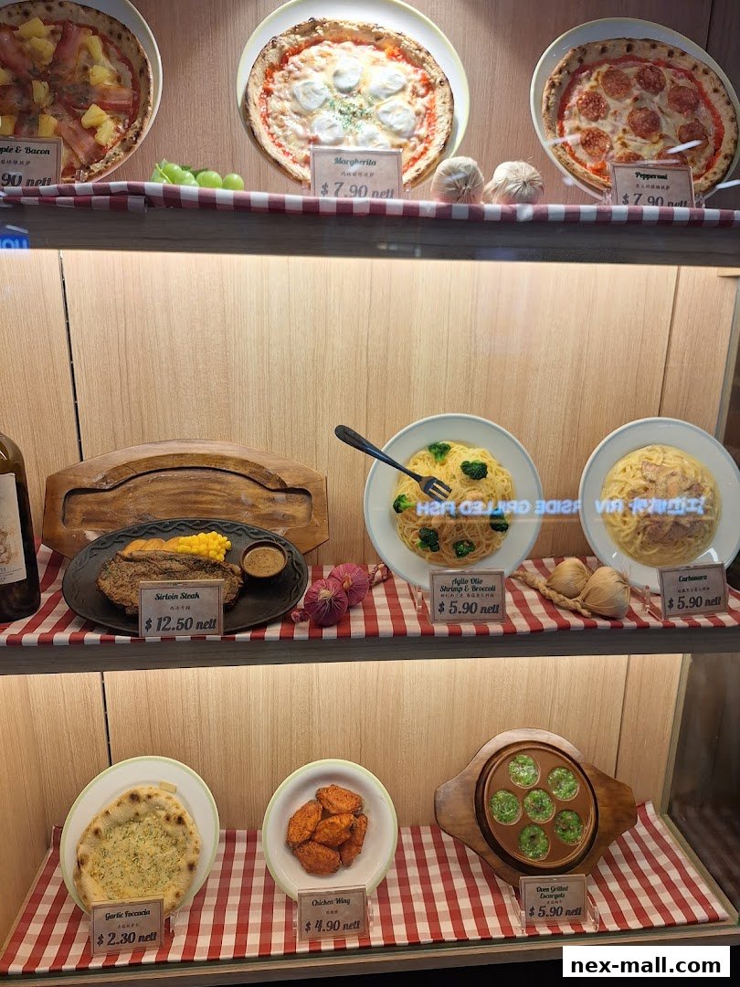 A display case showcasing various food items including pizzas, steak, pasta, chicken wings, and focaccia.