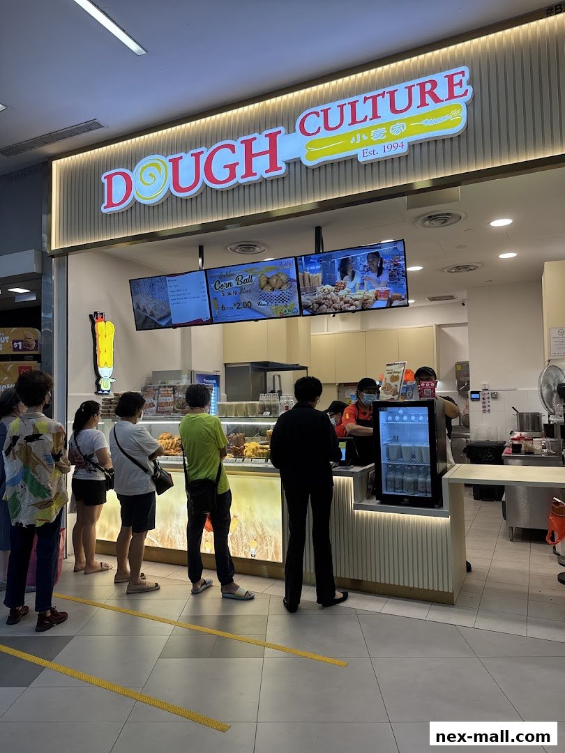 People queuing at Dough Culture shop with a bright sign and digital menus.