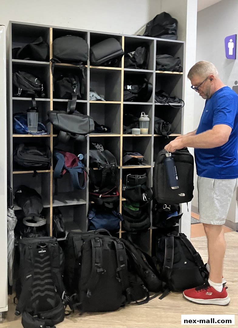 A man is organizing bags in a locker room at Anytime Fitness.