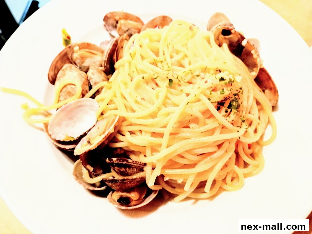 A plate of spaghetti with clams, garnished with herbs and garlic.