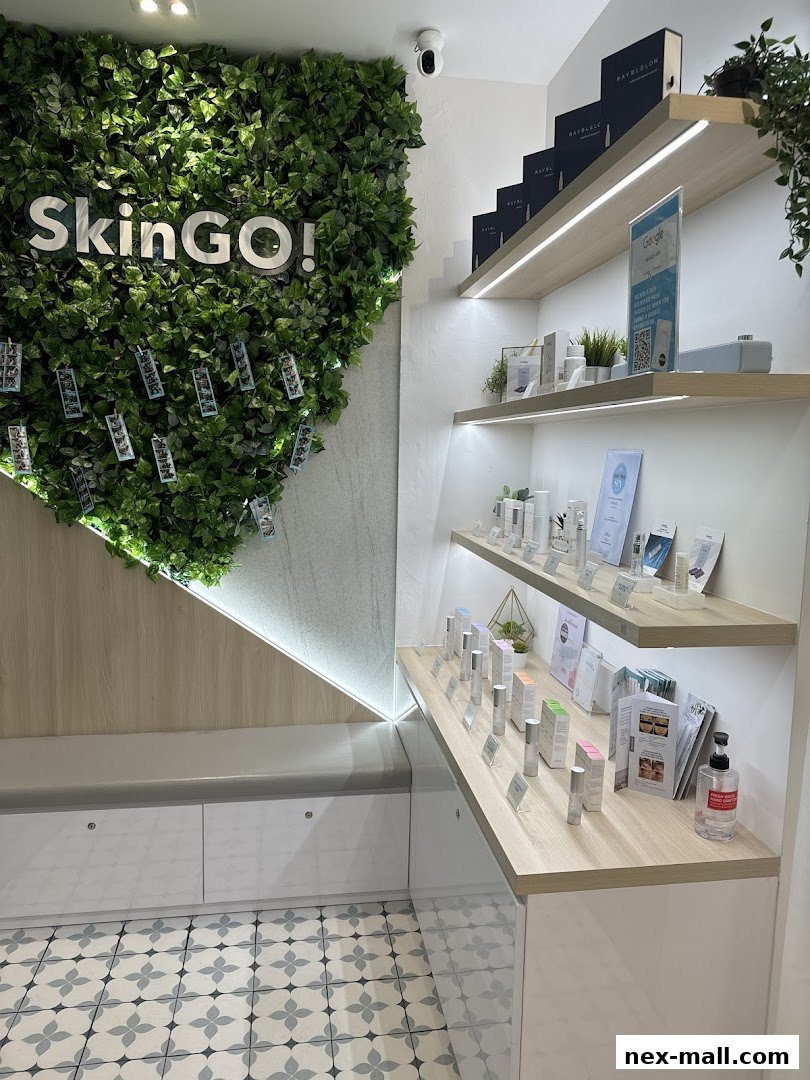 Interior of a modern skincare shop with a green wall, shelves displaying products, and a seating area.