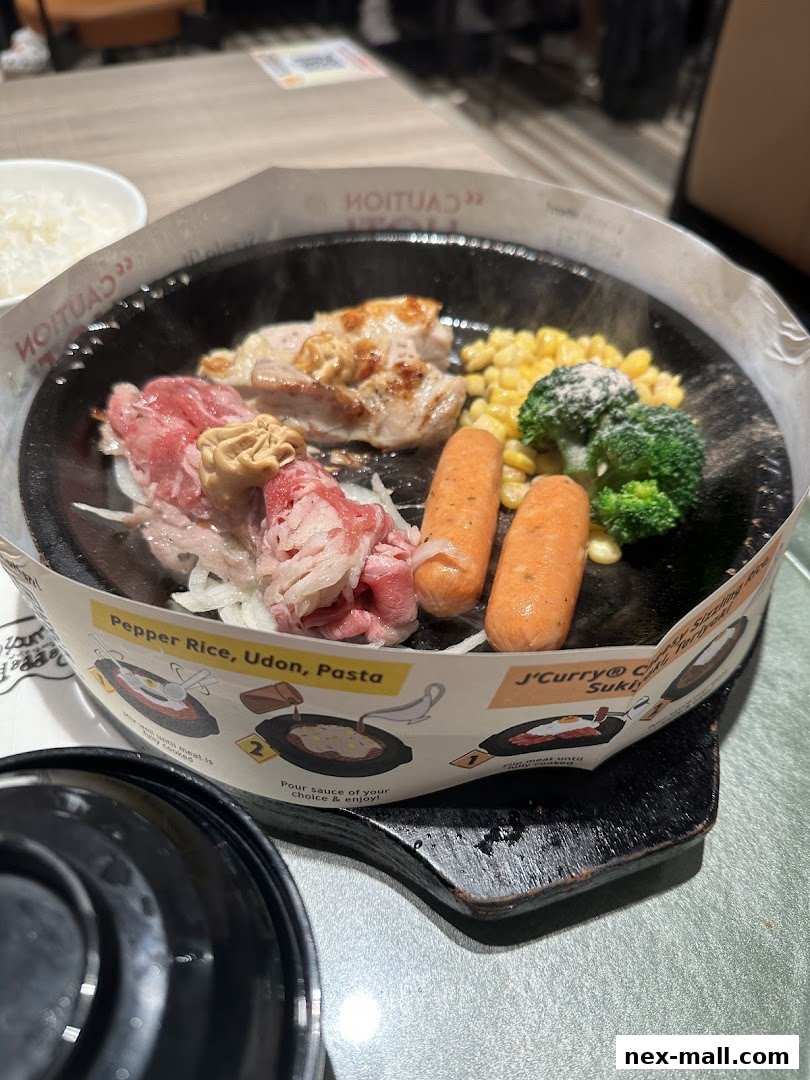 A sizzling hot plate meal with beef, chicken, sausages, broccoli, and corn.
