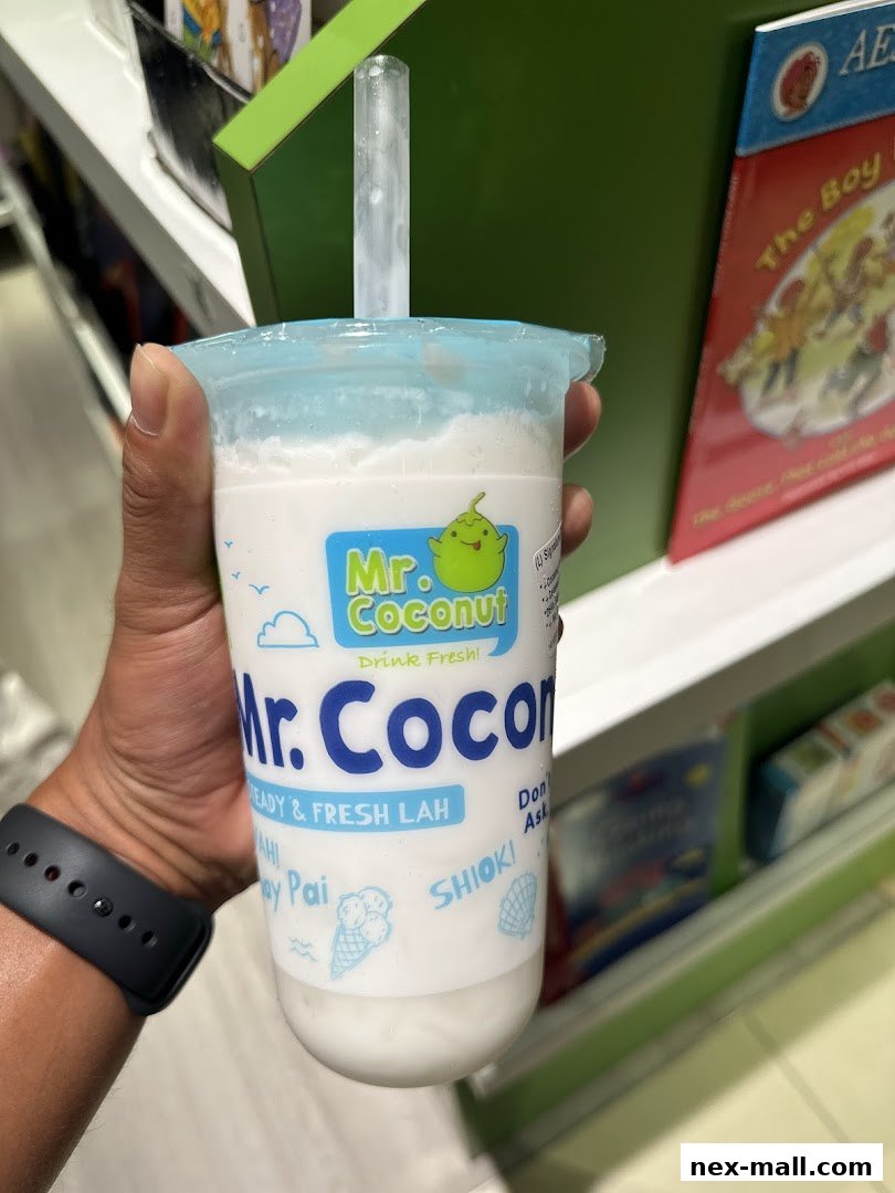 A hand holds a Mr. Coconut drink with a straw, showing the brand's logo and slogan.