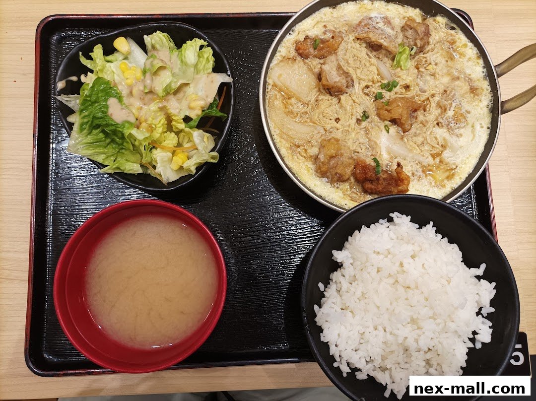A Japanese meal set featuring chicken katsu, rice, miso soup, and a side salad.