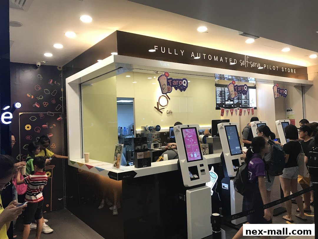 Customers queue at self-serve kiosks in a modern KOI Thé bubble tea shop.