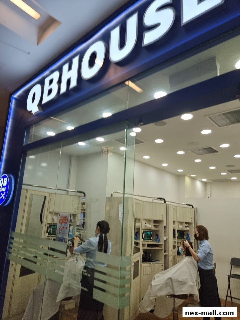 QB HOUSE NEX salon interior with stylists attending to clients.