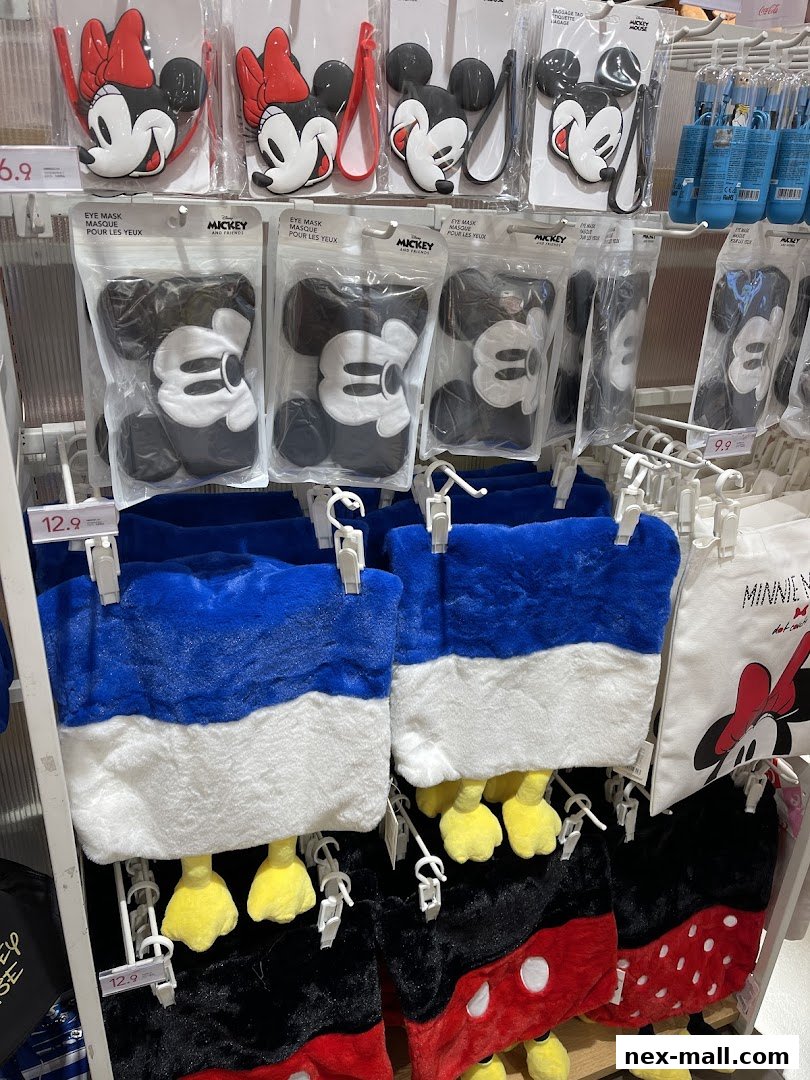 A display of Disney-themed merchandise, including eye masks and plush bags, at MINISO NEX.
