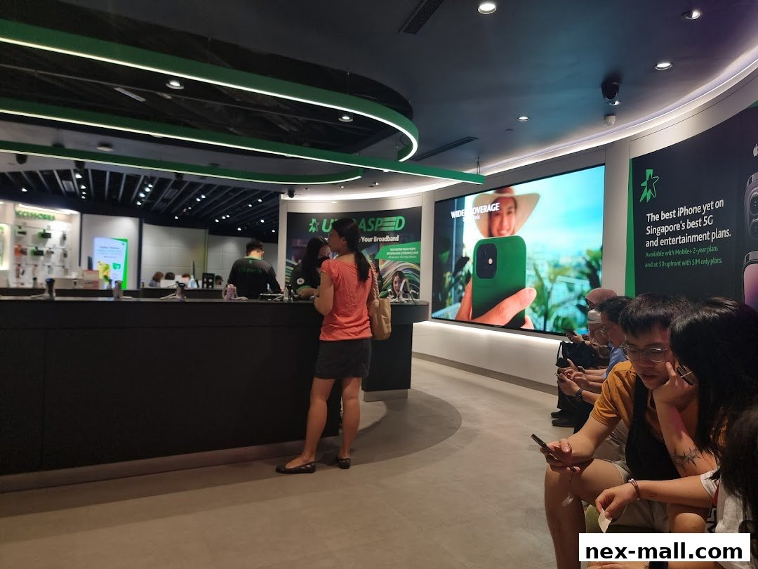Customers are waiting in line at a StarHub store with a large screen displaying an iPhone advertisement.