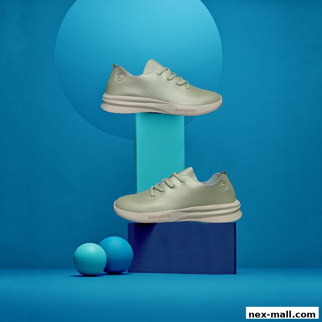 Two stylish light green sneakers displayed on blue pedestals against a blue background.