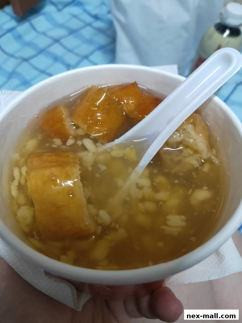 A close-up shot of a bowl of sweet soup with fried dough sticks and other ingredients.