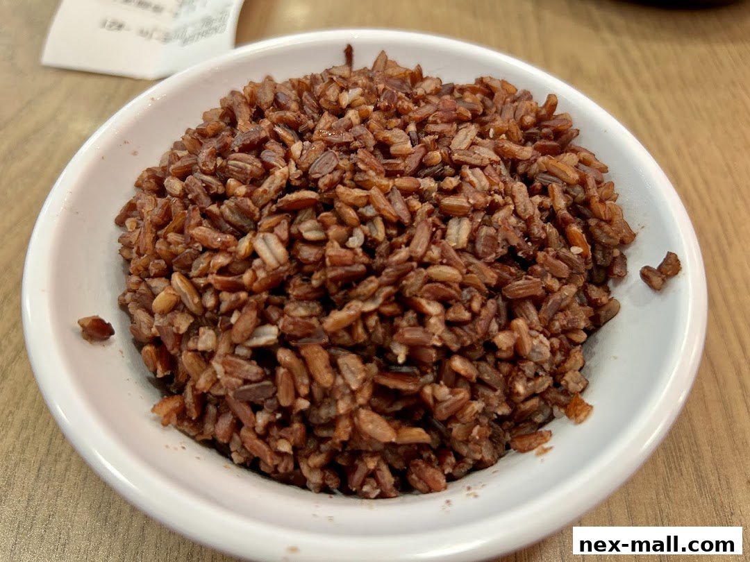A close-up shot of a bowl filled with brown rice, with a receipt visible in the background.