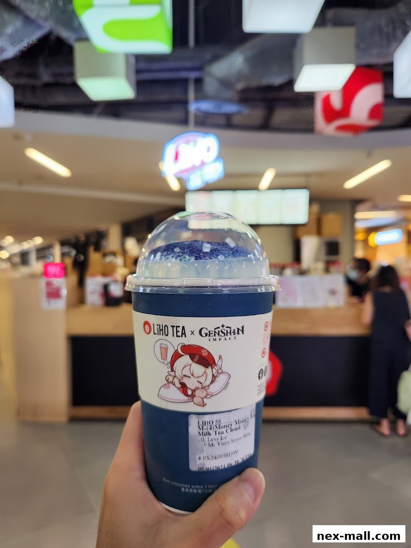A hand holds a LiHO TEA x Genshin Impact collaboration drink with a cute character.