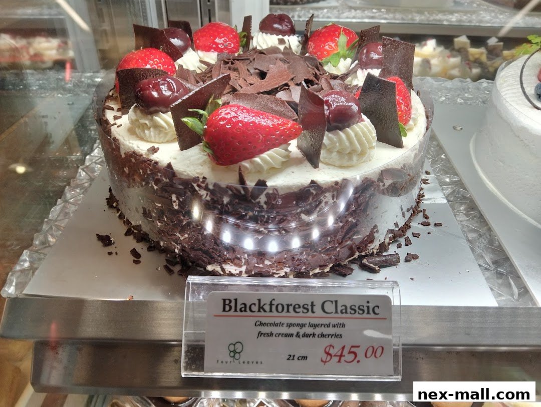A Black Forest cake decorated with strawberries, cherries, and chocolate shavings.