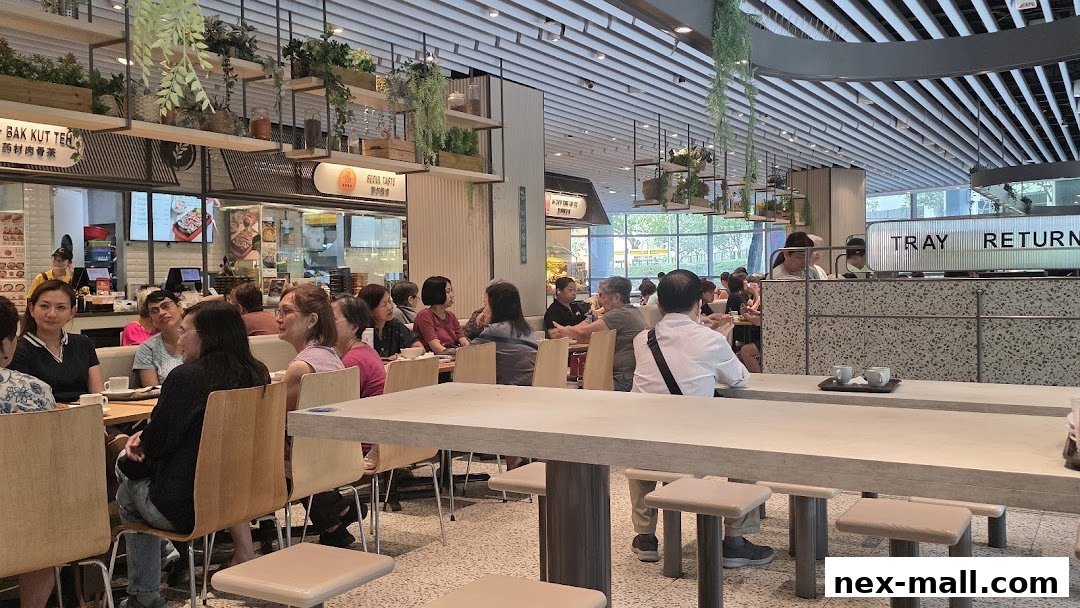 People dining at tables in a bright, modern food court with hanging plants.