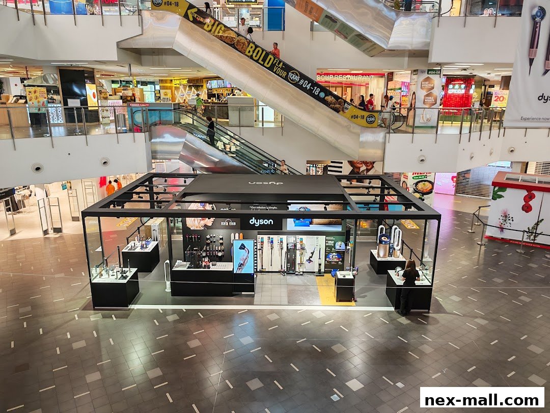 A Dyson pop-up store showcasing various vacuum cleaners and hair styling tools in a mall.