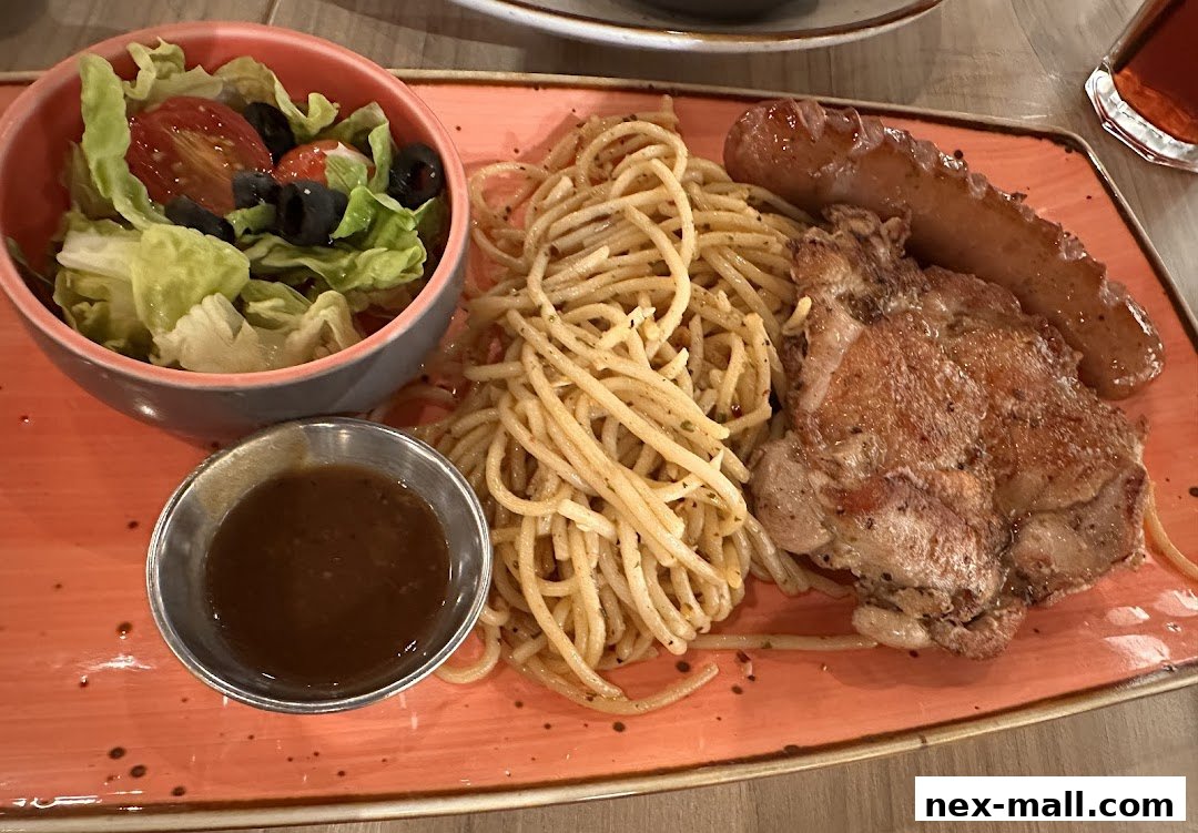 A plate of spaghetti with chicken, sausage, salad, and sauce.