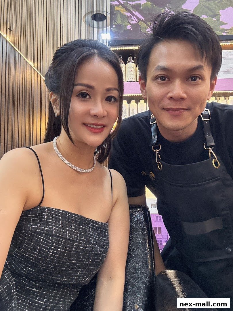 A woman and a man posing for a selfie in a salon, with shelves of products in the background.