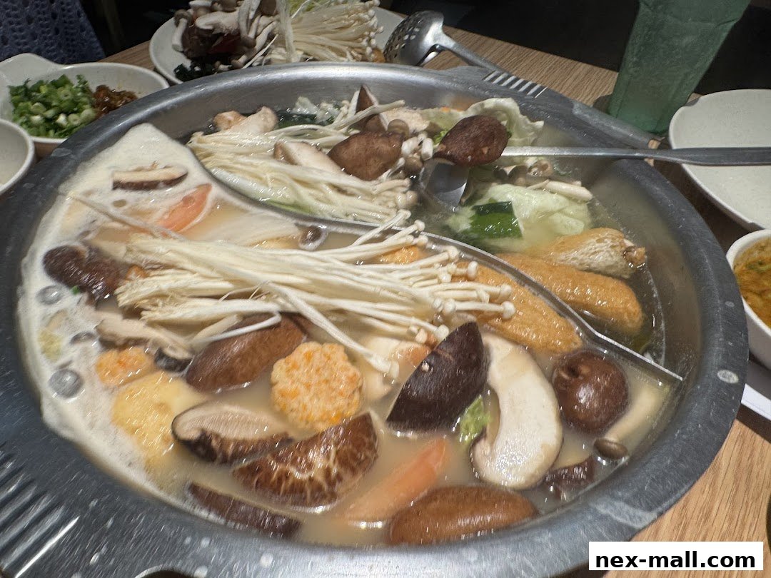 A steaming hot pot filled with various ingredients like mushrooms, vegetables, and tofu.