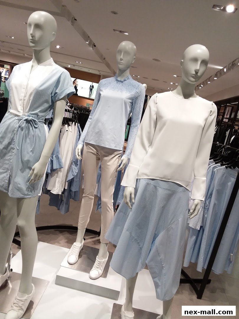 Mannequins display stylish light blue and white outfits in a retail store.